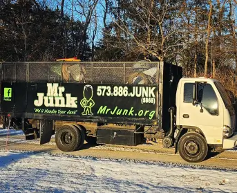 MrJunk® traveling the gravel roads in their big Isuzu junk truck in winter