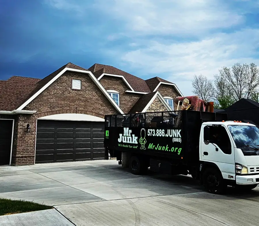 MrJunk® truck pulled up in front of a beautiful two story brick home on a fall day