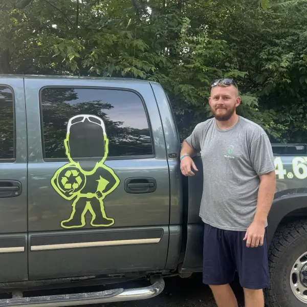 Trevor Brown standing in front of one of his MrJunk® service trucks with the corporate logo