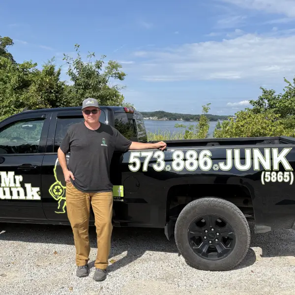 MrJunk® Chris Miller In Front of one of his black trucks at the Lake Of The Ozarks in the background